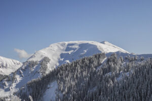 A picture of Kachina Peak in Taos Ski Valley, New Mexico on a wonderful blue sky day untracked before the chairlift was built. It's a very round mountain peak and this picture is looking at the round peak.